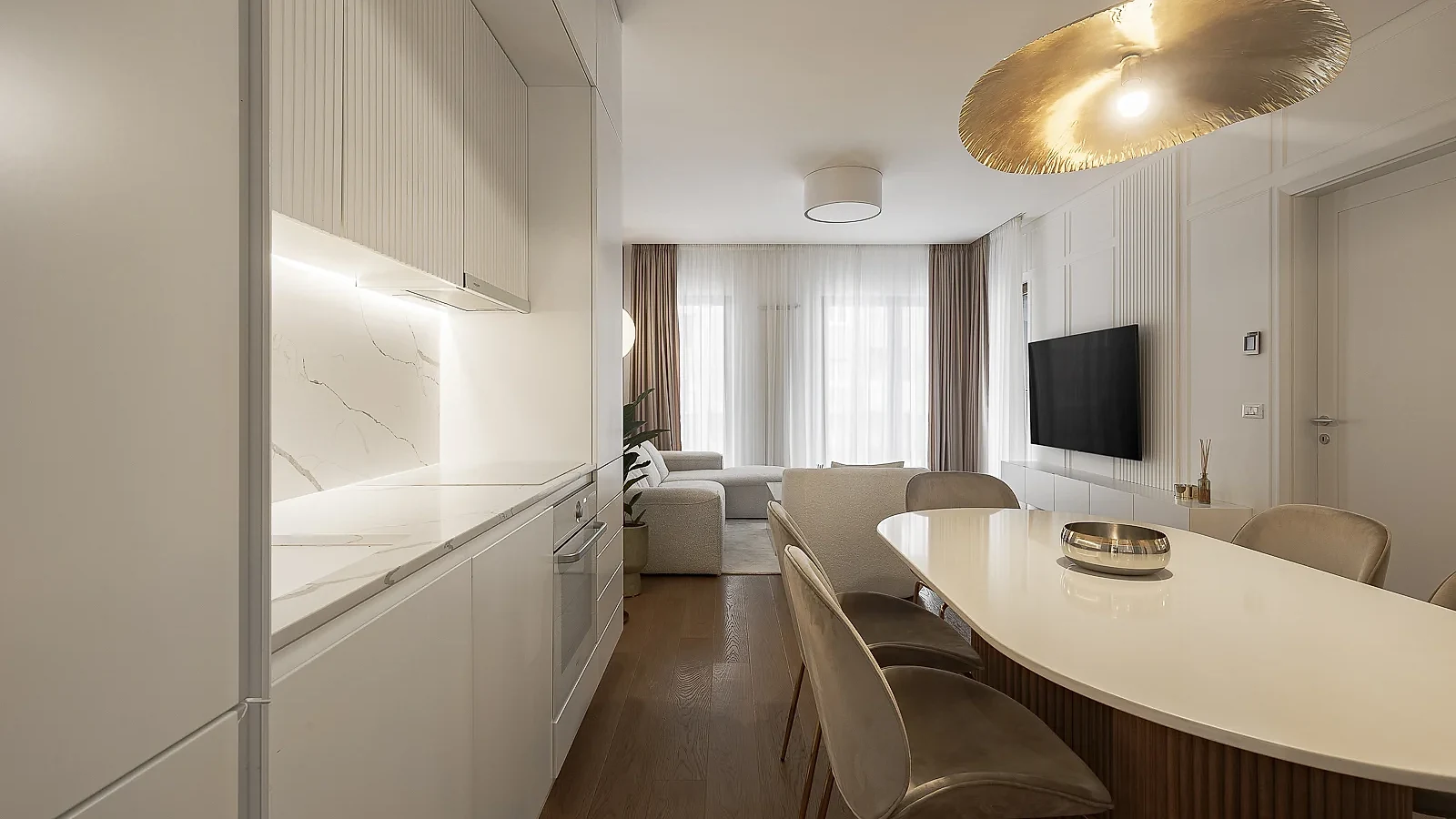 KMR Apartment kitchen and dining area with custom white joinery and warm wood flooring