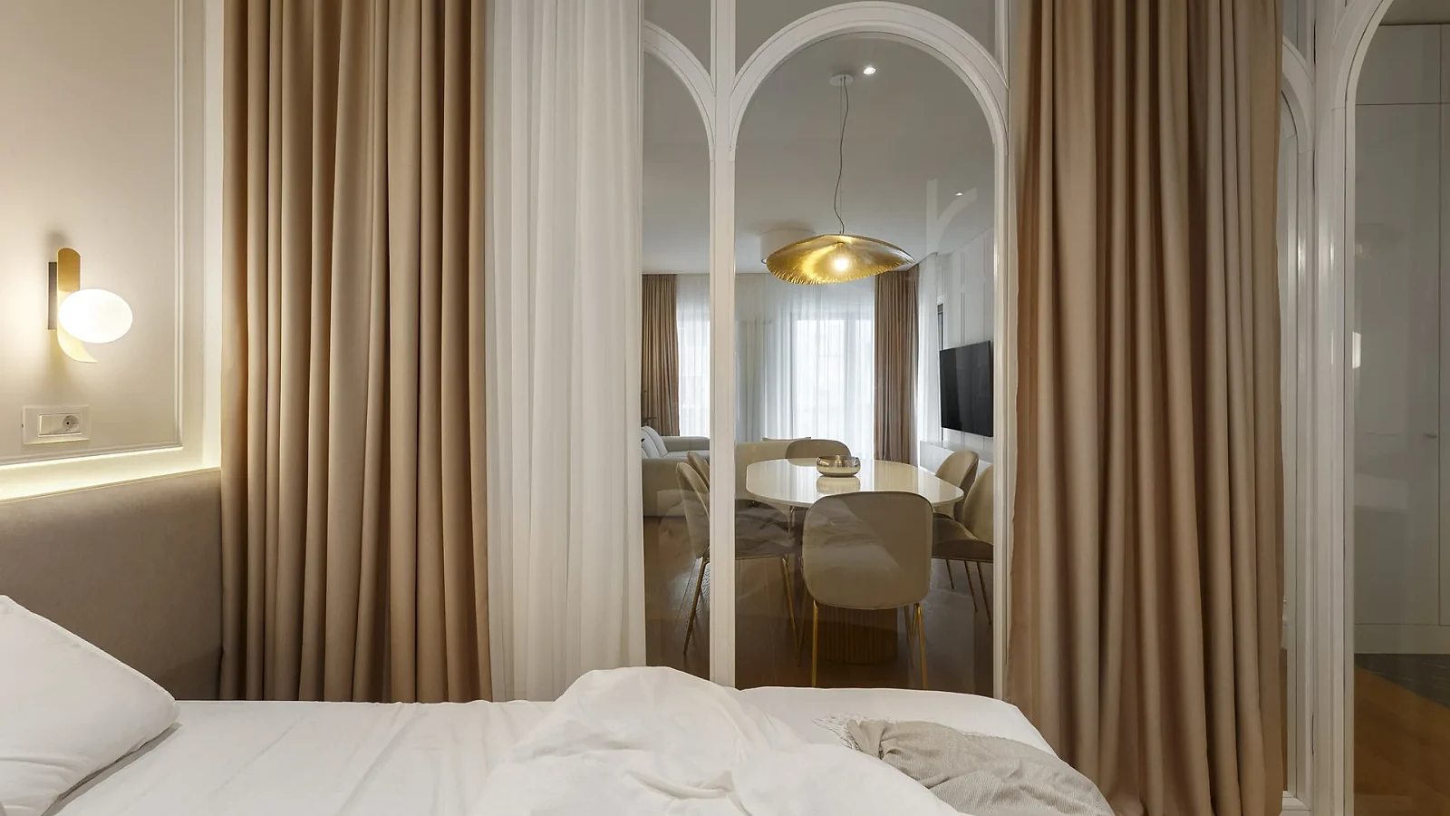 View from the KMR glass-enclosed bedroom toward the dining area through arched partitions