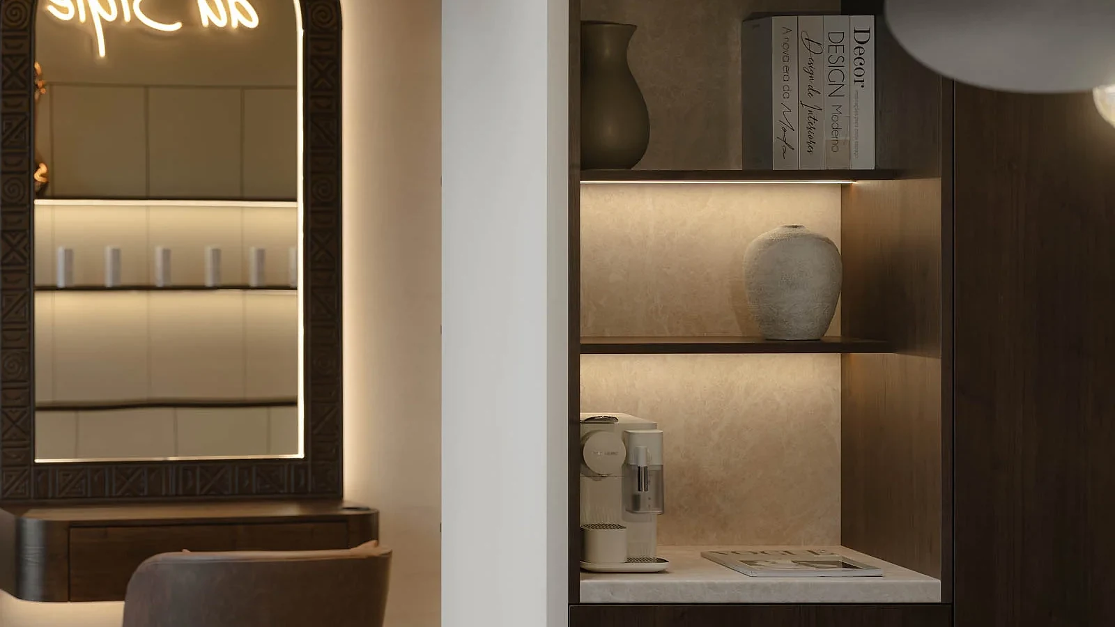 Illuminated arched mirror beside integrated storage and display niches at L'Atelier 35
