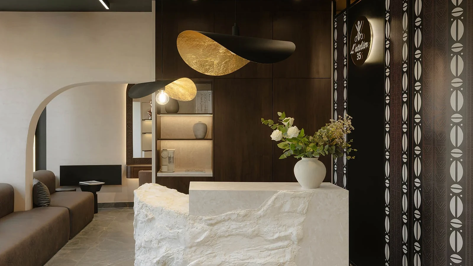 L'Atelier 35 waiting lounge, textured reception desk and curved patterned screen