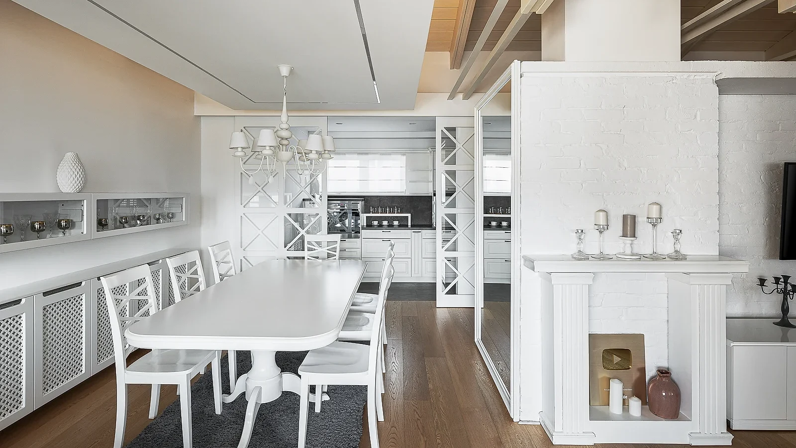 S27 dining area with a white table, chandelier and custom shelving around the fireplace