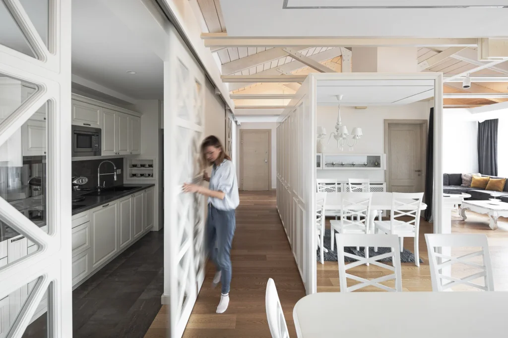 S27 Apartment kitchen and dining area with white joinery and exposed timber roof structure