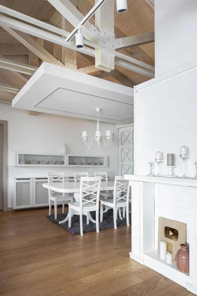 S27 dining room framed by the fireplace, white shelving and suspended ceiling plane