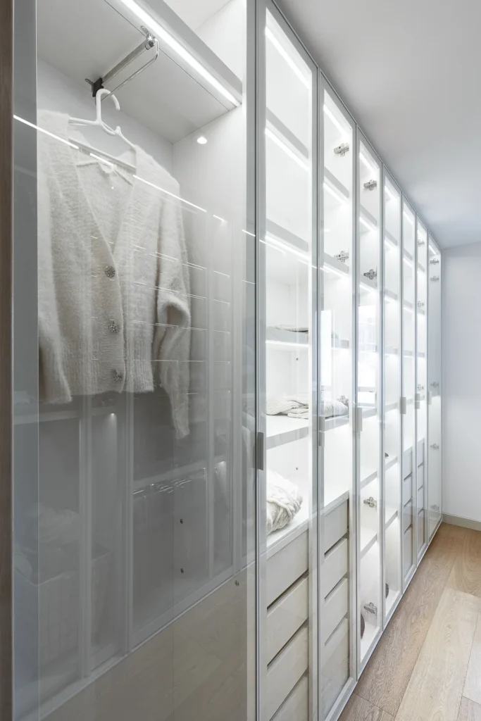 Glazed wardrobe with illuminated white cabinetry in the S27 Apartment
