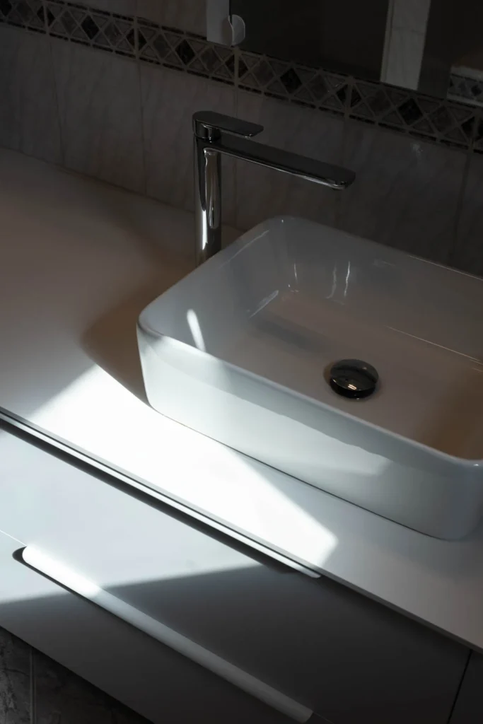 Sculptural white basin and dark vanity detail in the BP77 Apartment bathroom