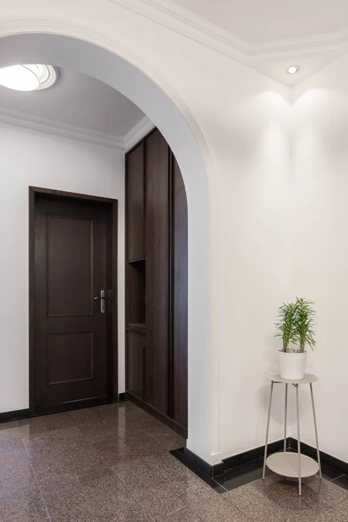 BP77 hallway with restored plaster arches, wall lights and original dark wood doors