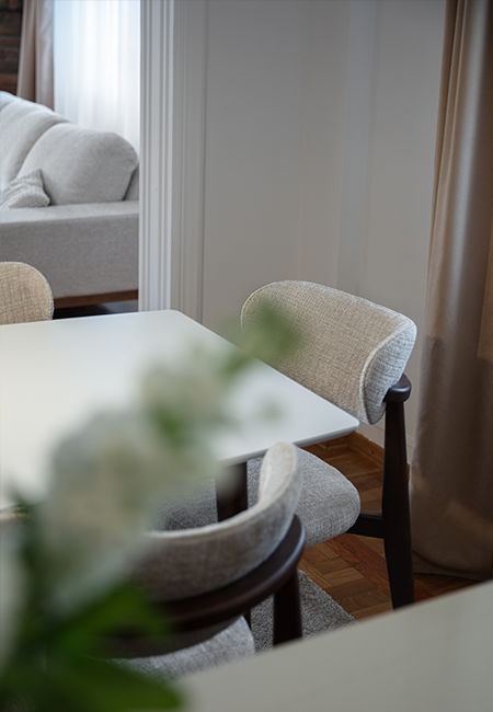 Soft neutral dining area opening toward the living room in a Jovana Stojković Studio interior