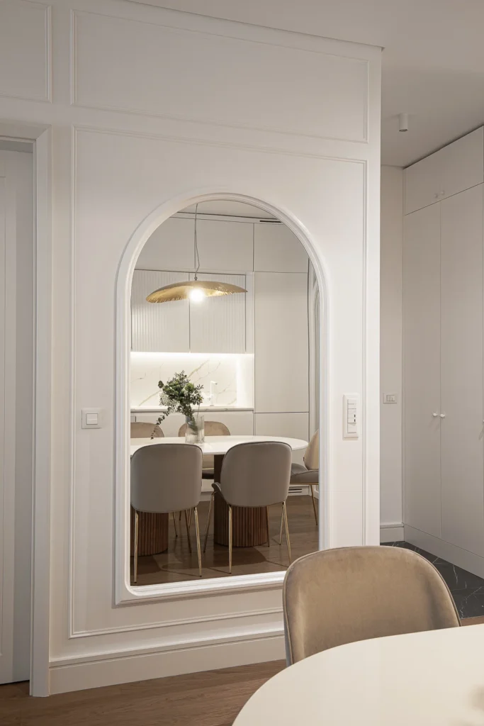 Arched mirror and custom wall panelling beside the KMR Apartment dining area