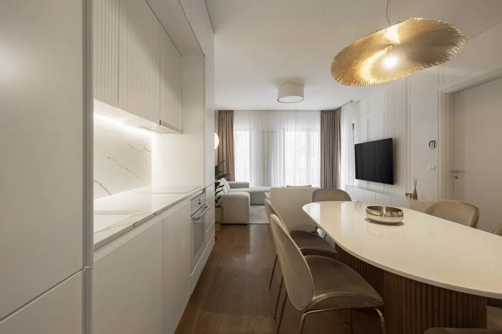 KMR Apartment kitchen and dining area with custom white joinery and warm wood flooring