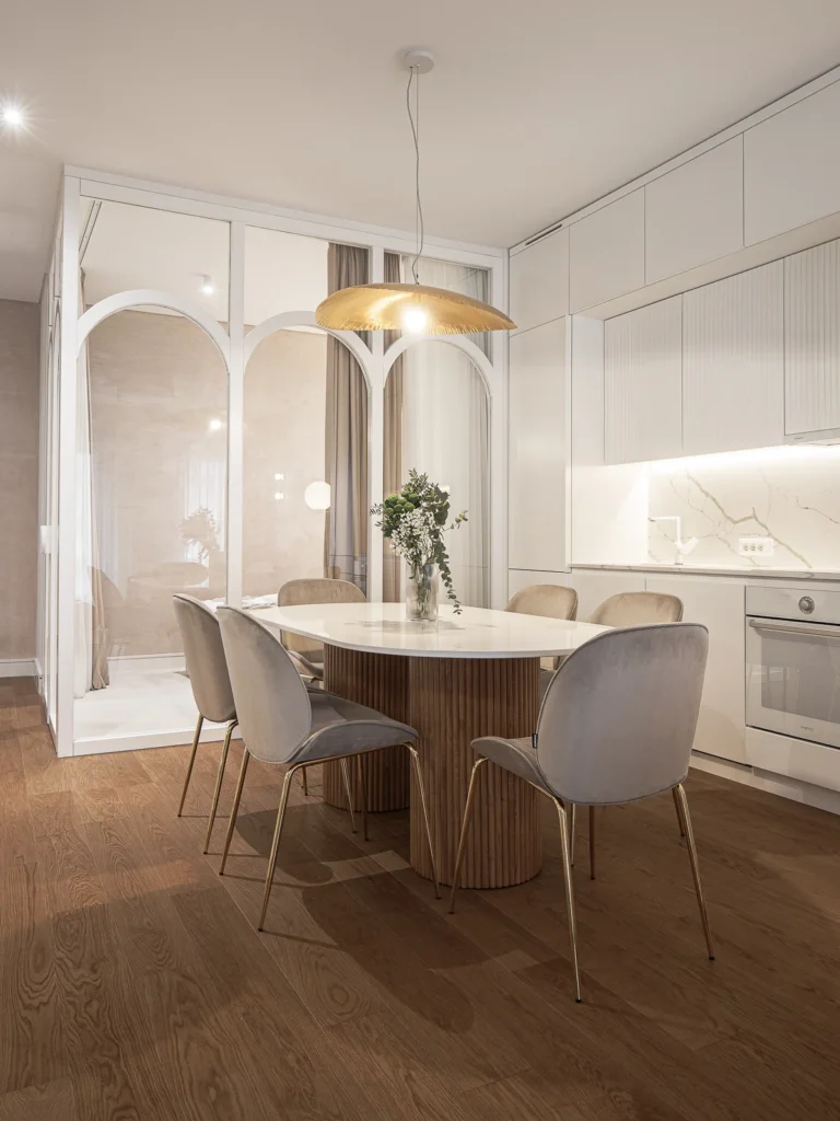 KMR dining area opening toward the kitchen through arched glass partitions