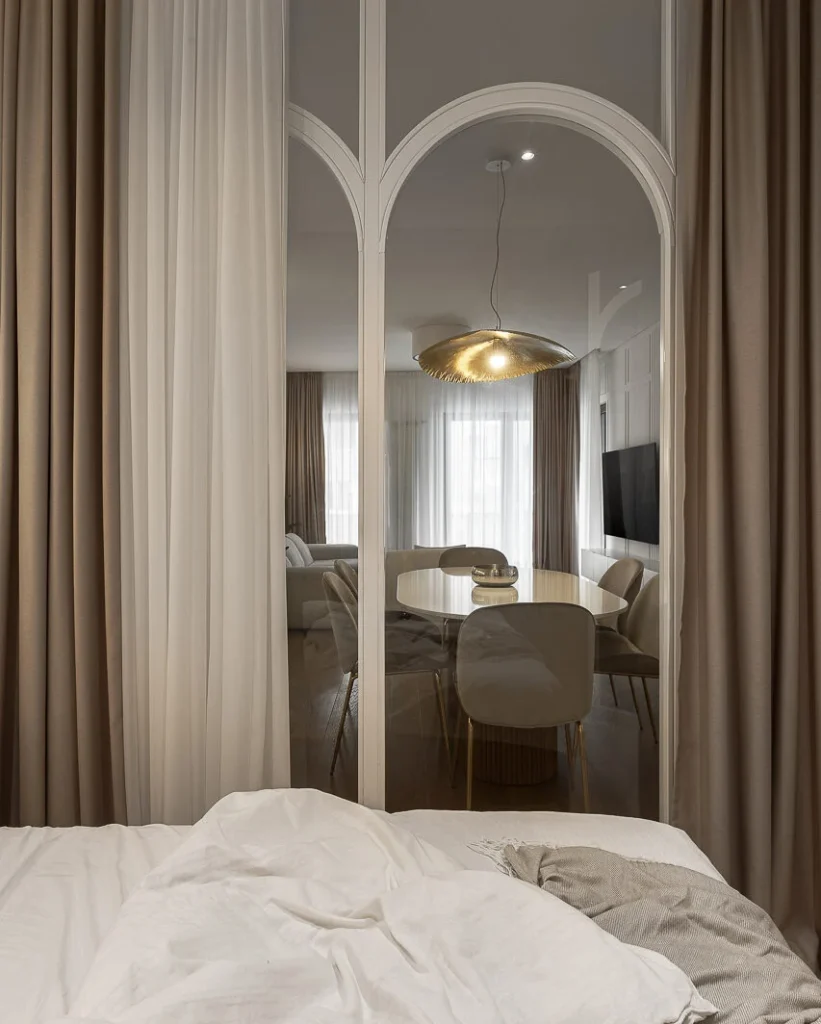 View from the glass-enclosed KMR bedroom toward the dining area through arched glazing