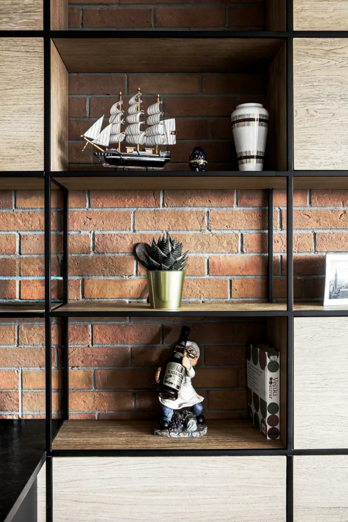 Open timber and black metal shelving with curated objects in A75 Apartment