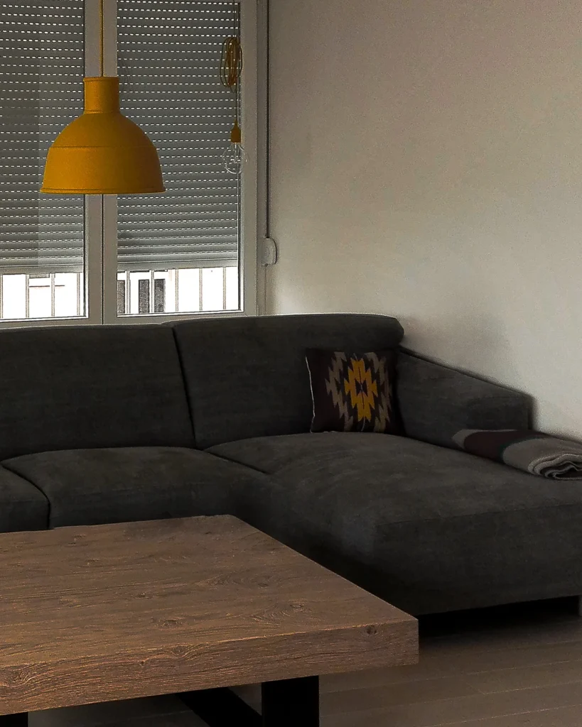 A75 Apartment living room with a charcoal sectional sofa and solid wood coffee table