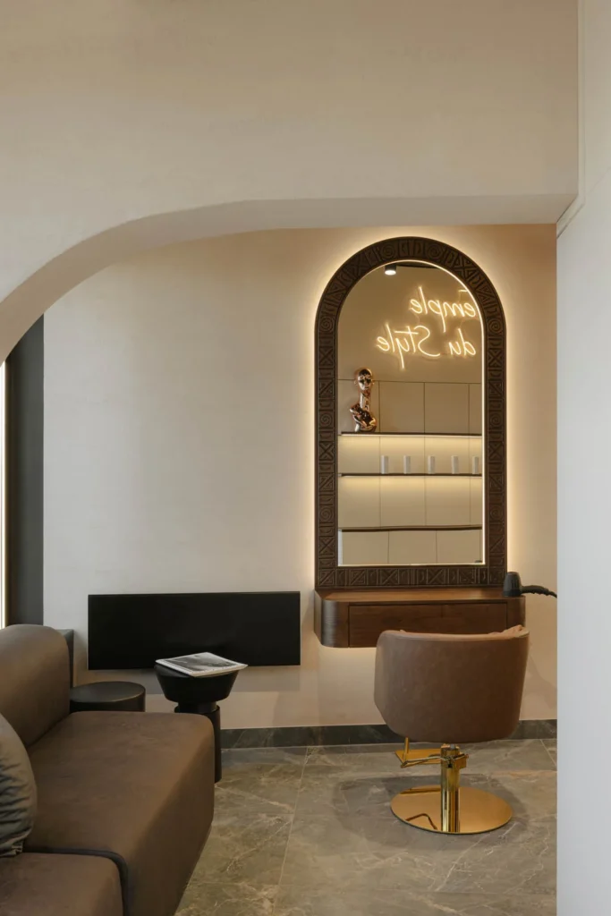 Women's styling alcove with an arched mirror and tan salon chair at L'Atelier 35