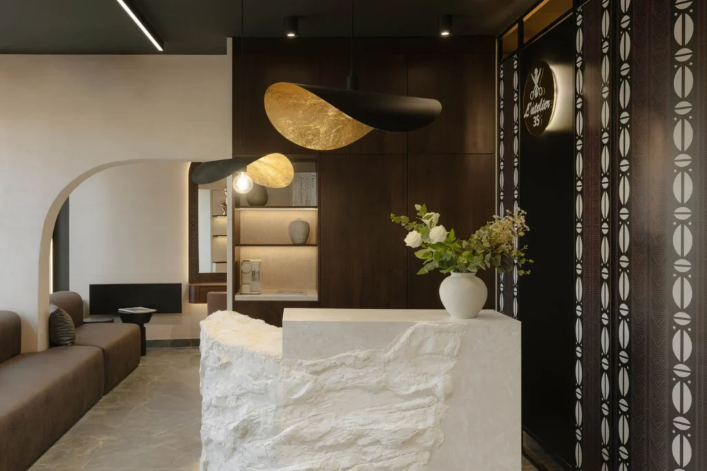 L'Atelier 35 waiting lounge, textured reception desk and curved patterned screen