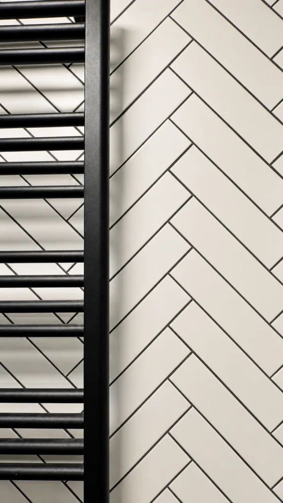 MC33 Apartment bathroom detail with black towel radiator and chevron wall tiles