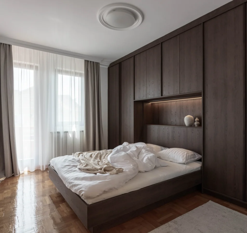 BP77 bedroom with full-height dark oak wardrobes and an integrated upholstered bed
