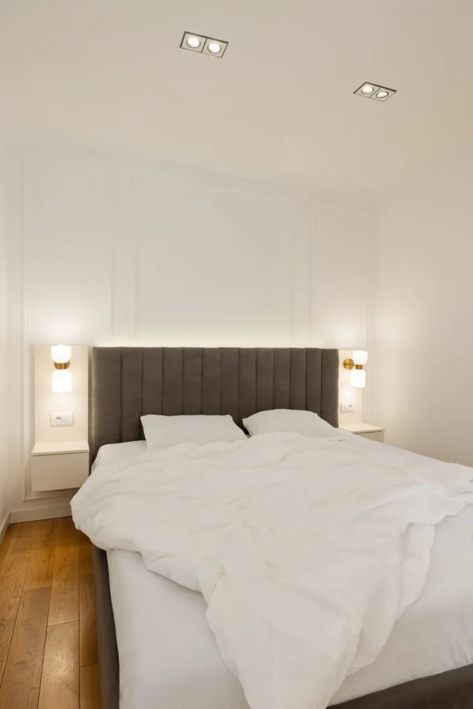 MBS Master Suite bedroom with taupe upholstered headboard and integrated wall lighting
